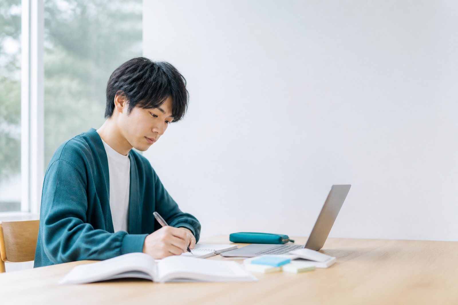 経済学の教科書とノートPCを開いて数式を追う受講者