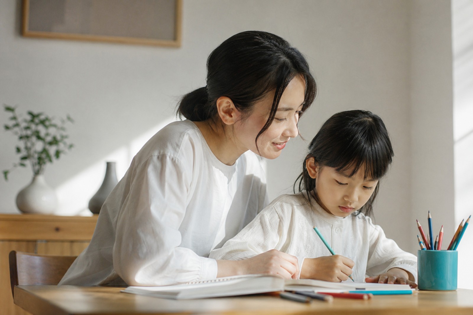 リビングで小学生の子どもの宿題を見守る親
