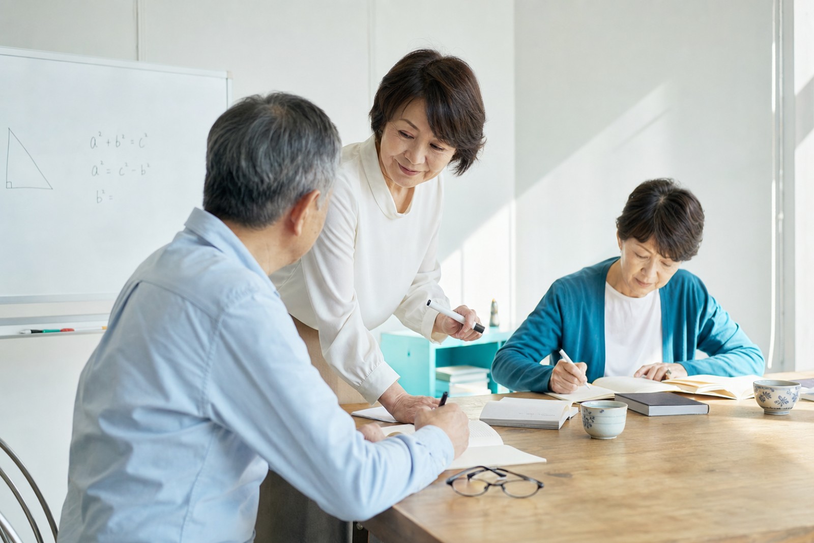 明るい教室で講師と穏やかに数学を学ぶシニア
